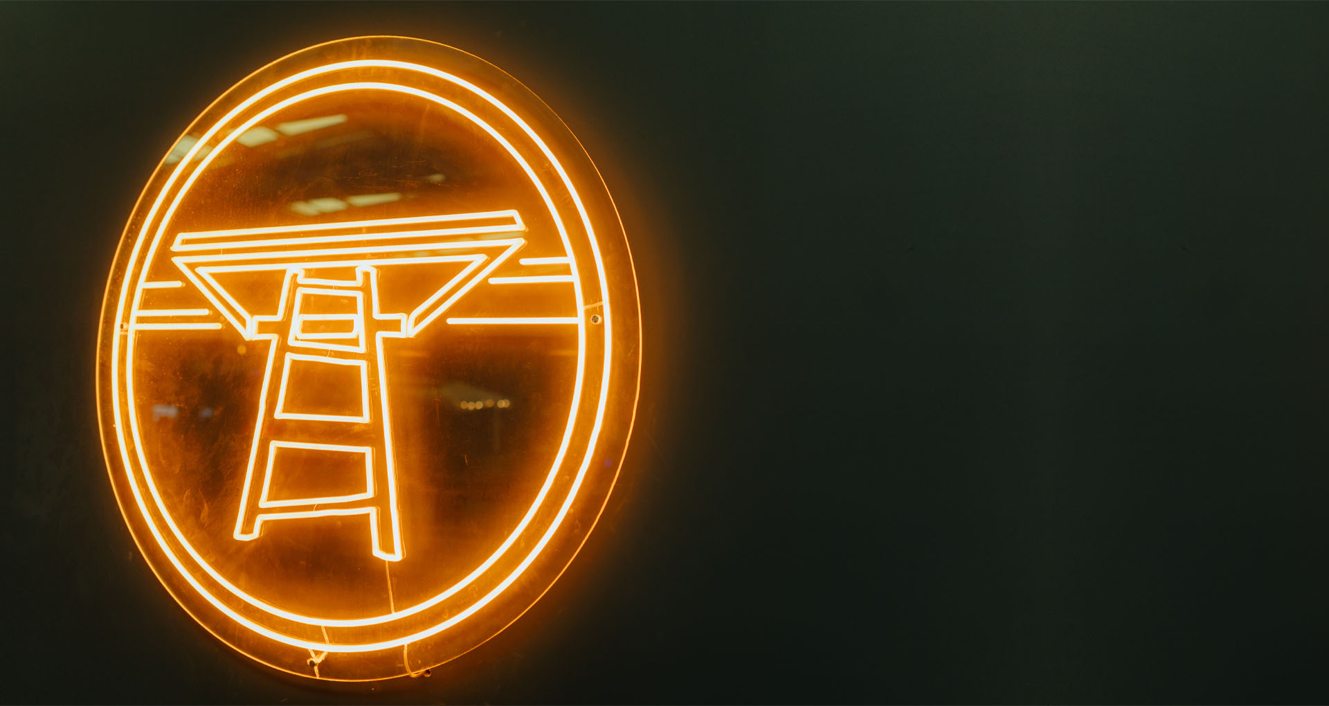 A neon hanging sign featuring the Treehouse digital logo.